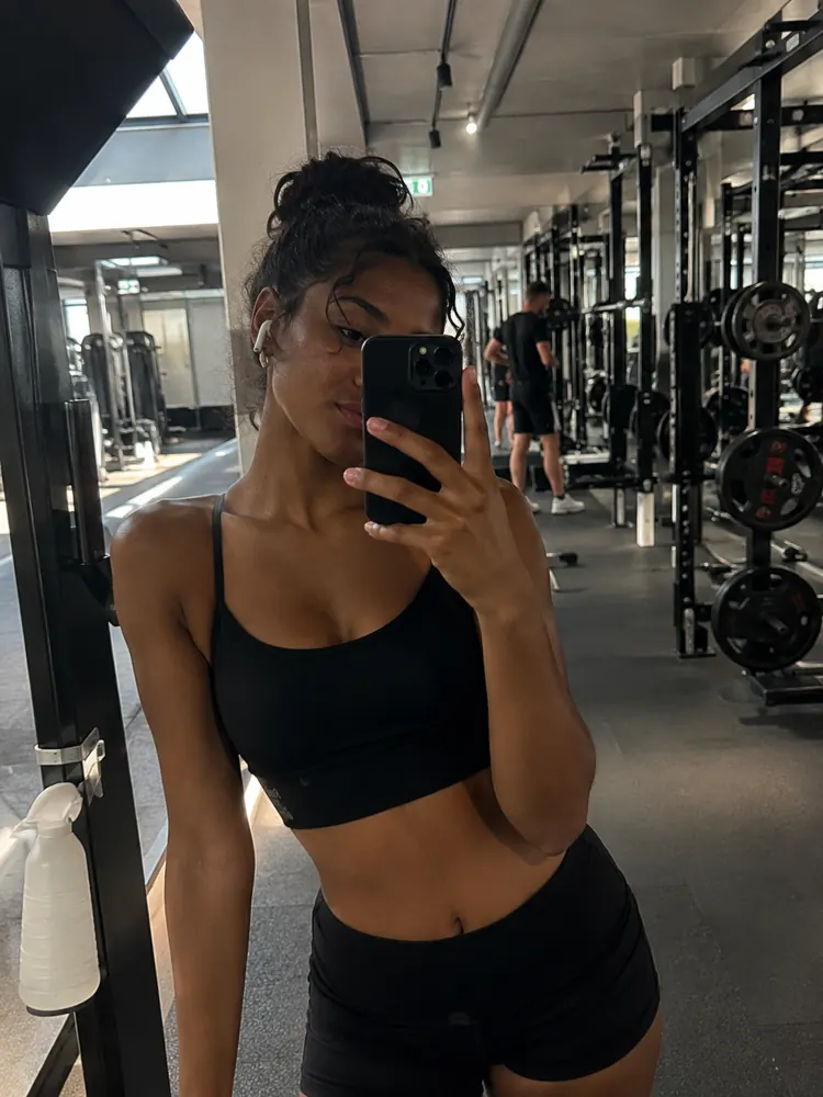 Woman taking a mirror selfie in the gym